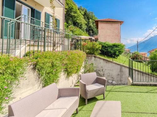 a patio with a couch and chairs on the grass at Apartment Il Melo-2 by Interhome in Garzeno