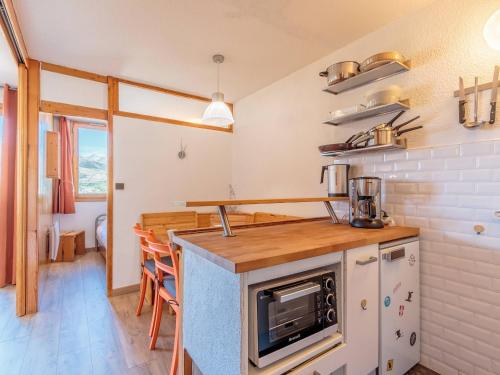 une cuisine avec un comptoir avec une cuisinière et un four dans l'établissement 2 Pièces cosy avec balcon - La Plagne - FR-1-353-20, à La Plagne