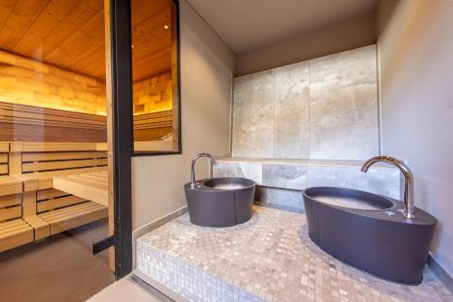 two tubs in a bathroom with a sauna at Hotel Kreuz & Post Grindelwald in Grindelwald