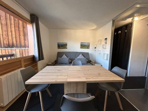 une pièce avec une table, des chaises et un canapé dans l'établissement Appartement skis aux pieds pour 6 pers, Plagne Villages - FR-1-351-75, à La Plagne