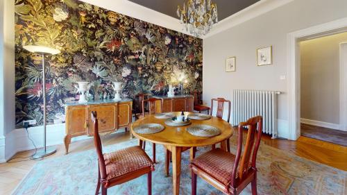 une salle à manger avec une table et des chaises ainsi qu'une fresque murale. dans l'établissement Le Saint Nicolas, à Strasbourg