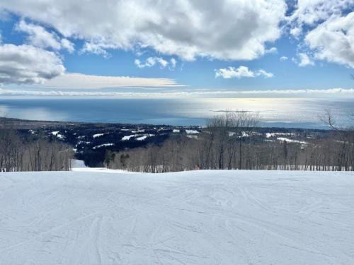 a snow covered slope with a view of the ocean at Ski in Ski out 1 Bed plus Loft BEST VIEWS IN LUTSEN in Lutsen