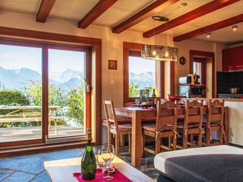 uma cozinha e sala de jantar com mesa, cadeiras e montanhas em Chalet Nelly by Interhome em Veysonnaz