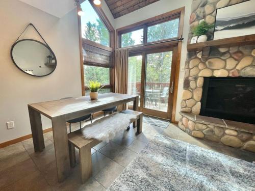 a dining room with a table and a fireplace at Ski in Ski out Townhome, Indoor and outdoor pools, hot tub, fire pits, and more in Lutsen