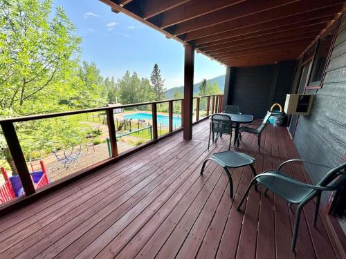 a deck with chairs and tables and a view of a pool at Condo at Lutsen Mtn, Ski in Ski out, Gorgeous views of Moose Mtn in Lutsen