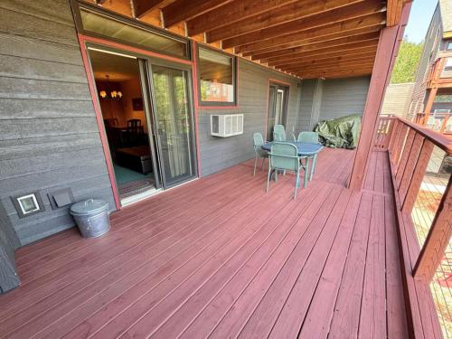 a wooden deck with a table and chairs on a house at Condo at Lutsen Mtn, Ski in Ski out, Gorgeous views of Moose Mtn in Lutsen