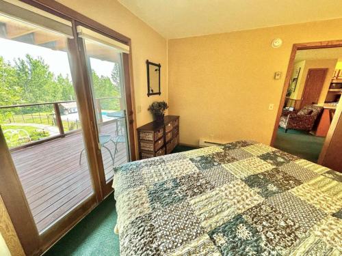 a bedroom with a bed and a balcony at Condo at Lutsen Mtn, Ski in Ski out, Gorgeous views of Moose Mtn in Lutsen