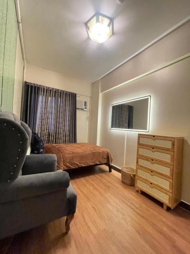 a bedroom with a bed and a couch and a chair at Two Bedroom with Balcony 70sqm -Pasig in Manila