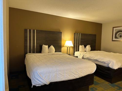 a hotel room with two beds with white sheets at Hotel Inn Milwaukee in Milwaukee