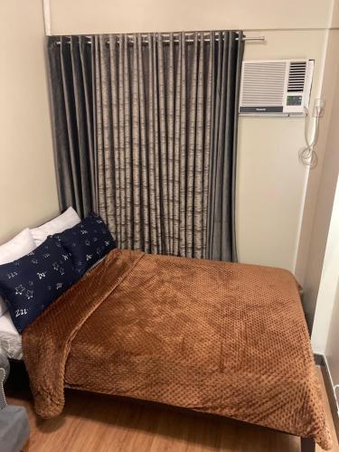 a small bedroom with a bed and a window at Two Bedroom with Balcony 70sqm -Pasig in Manila