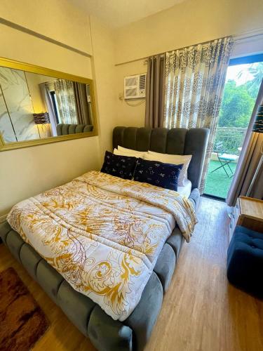 a bedroom with a large bed with a large window at Two Bedroom with Balcony 70sqm -Pasig in Manila