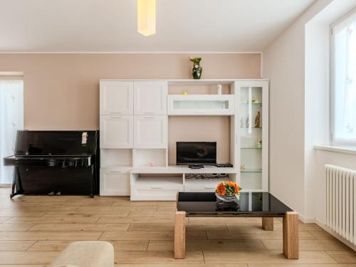 a living room with white cabinets and a coffee table at Apartment Il Melo-1 by Interhome in Garzeno