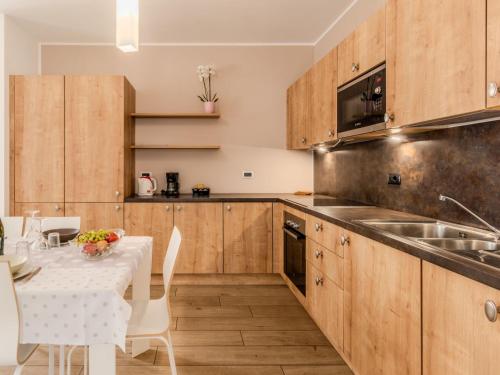 a kitchen with wooden cabinets and a table with a white table cloth at Apartment Il Melo-1 by Interhome in Garzeno