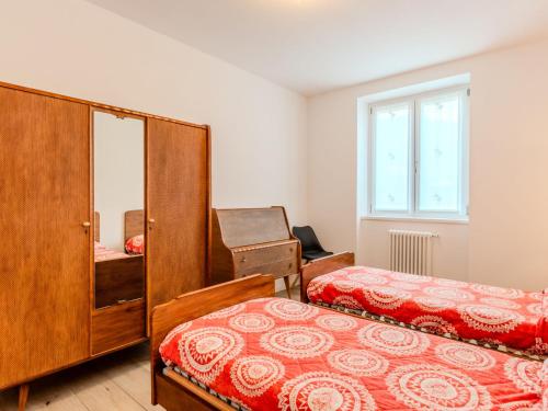 a bedroom with two beds and a cabinet and a window at Apartment Il Melo-1 by Interhome in Garzeno