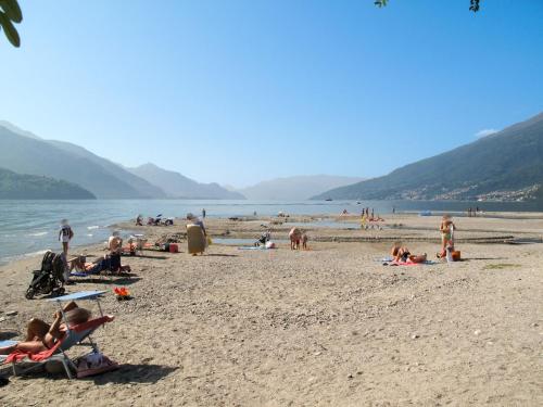 a group of people on a beach near the water at Apartment Il Melo-1 by Interhome in Garzeno