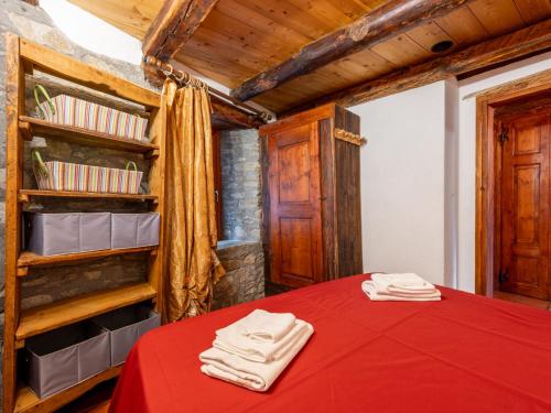 a bedroom with a red bed and a book shelf at Apartment Baita del Celtico 2 by Interhome in Advise