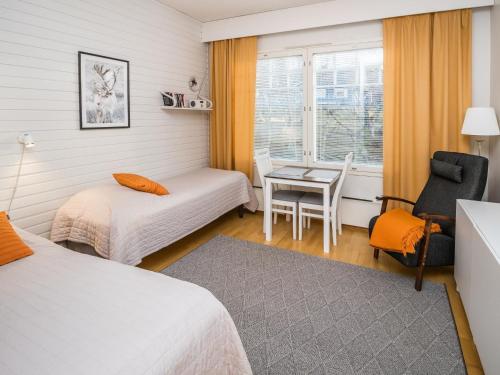 a room with two beds and a table and a chair at Holiday Home Rautulampi g14 by Interhome in Saariselka