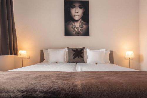 Schlafzimmer mit einem Bett mit Bild einer Frau in der Unterkunft Alpen-Appartements Zürcher in Kappl