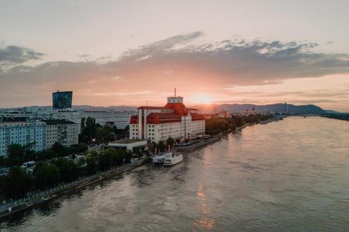a view of a river with buildings and a city at Hilton Vienna Waterfront in Vienna