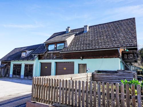 a house with a wooden fence in front of it at Apartment Ferienwohnung Gartenblick by Interhome in Öblarn