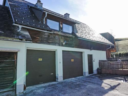 a garage with two garage doors on a house at Apartment Ferienwohnung Gartenblick by Interhome in Öblarn
