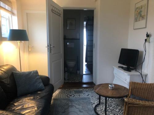 a living room with a couch and a television at Appartement in schuur in Twisk
