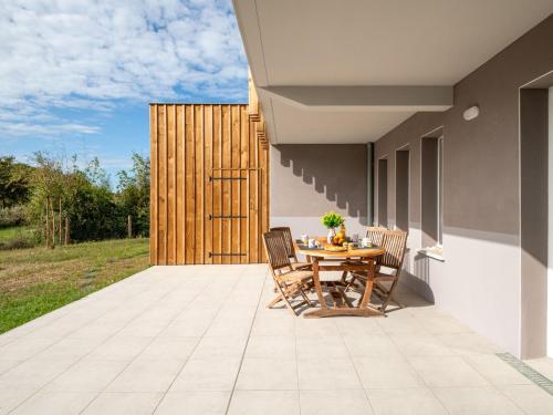 a patio with a wooden table and chairs on it at Apartment Jade et Elena-4 by Interhome in Lit-et-Mixe