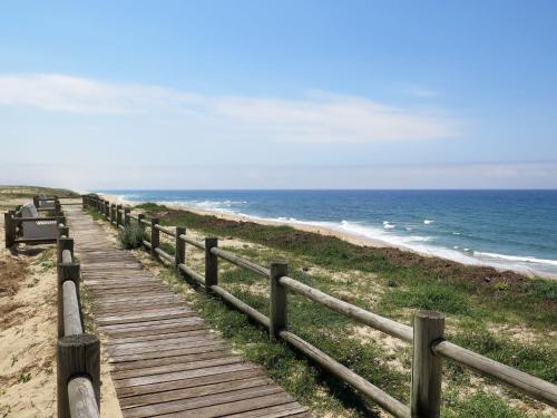 a wooden boardwalk leading to the ocean on a beach at Apartment Jade et Elena-4 by Interhome in Lit-et-Mixe