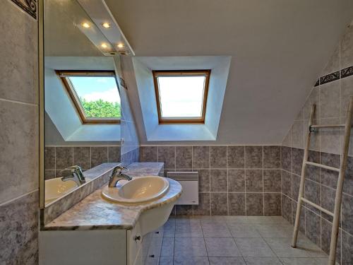 a bathroom with a sink and a tub and two windows at Holiday Home Villa au Parc Ny by Interhome in Pénestin