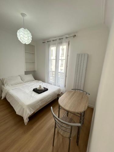 une chambre avec un lit, une table et une chaise dans l'établissement Comfortable studio Notre-Dame de Lorette Rodier, à Paris