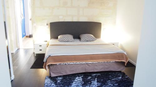 une chambre avec un grand lit avec une tête de lit dans l'établissement ATYPIQUE Grand théâtre, à Bordeaux