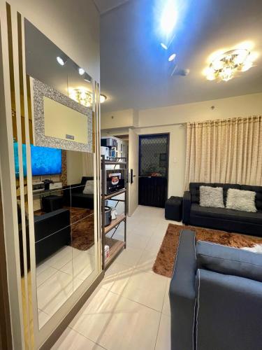 a living room with a blue couch and a television at Two Bedroom with Balcony 70sqm -Pasig in Manila