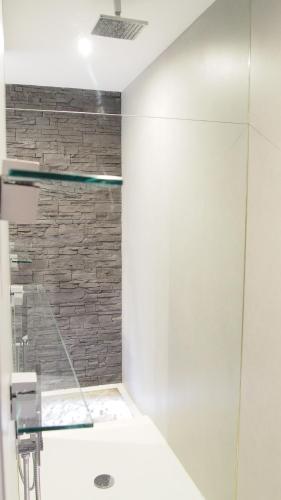 une salle de bain avec un lavabo et une douche en verre dans l'établissement ATYPIQUE Grand théâtre, à Bordeaux