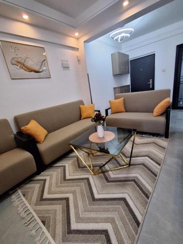 a living room with two couches and a rug at Kilimani Luxurious 2 bedroom in Nairobi