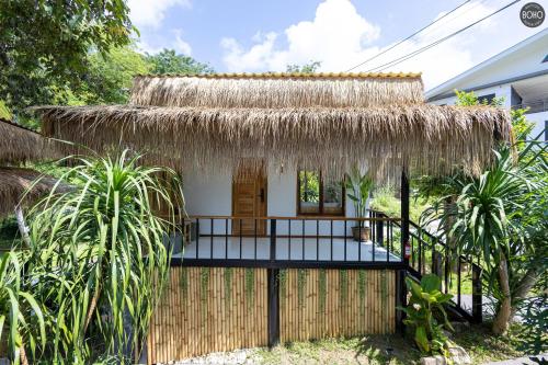 a small house with a thatched roof at BOHO Boutique Bungalows in Baan Tai