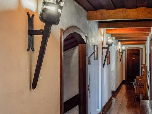 a hallway with a cross on the wall and a light on the wall at Mansão Nacional Inn in Campos do Jordão