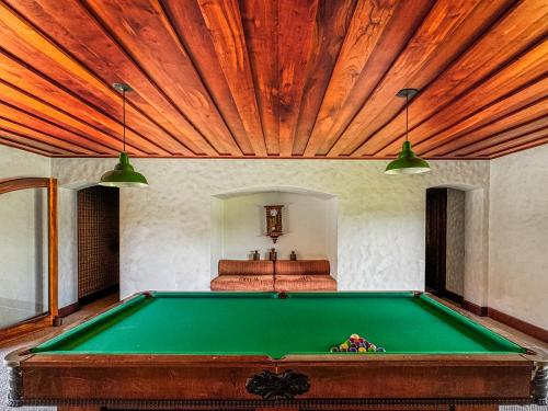 a pool table in a room with a bed at Mansão Nacional Inn in Campos do Jordão