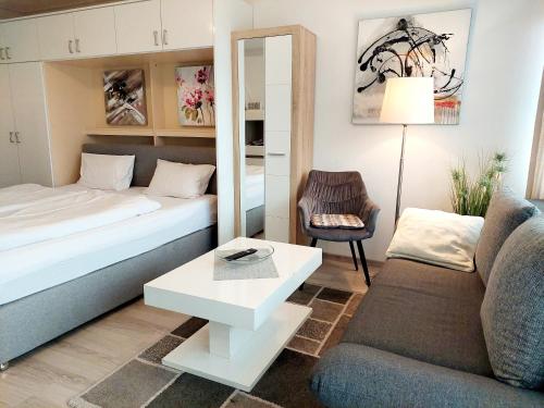 a small living room with a bed and a couch at Appartementhaus Berlin in Bad Füssing