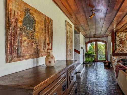 a living room with a vase on a wooden table at Mansão Nacional Inn in Campos do Jordão