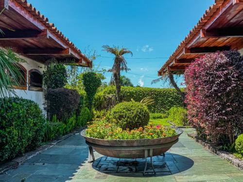 a garden with a large planter with flowers in it at Mansão Nacional Inn in Campos do Jordão