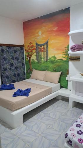 a room with a bed with a painting on the wall at Rêve des Îles Guesthouse in Rodrigues Island