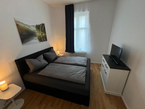 a small bedroom with a bed and a window at Rosen Appartements in Neubrandenburg