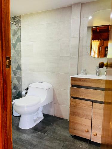 a bathroom with a white toilet and a sink at Finca Maracuba Cabañas Limón, Manzana y Níspero in Jardin