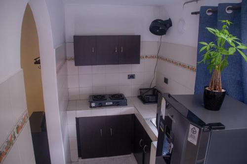 a small kitchen with a sink and a stove at La Familia Hostel - Manila in Medellín