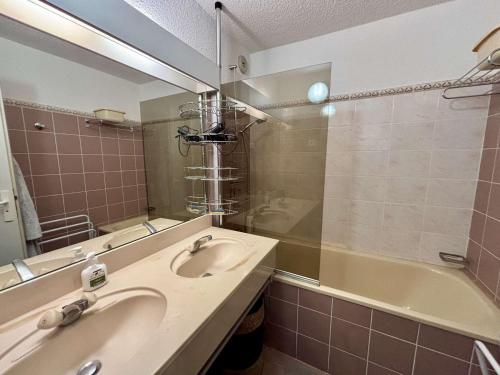 une salle de bain avec un lavabo, une baignoire et un miroir dans l'établissement Studio cabine confortable, 30m², 5 pers, piscine, balcon, proche pistes, commerces - Alpe d'Huez - FR-1-405-361, à Huez