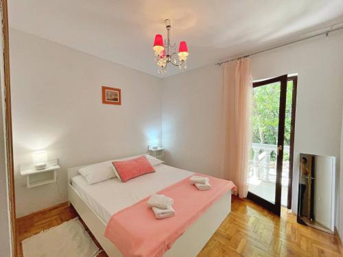 sypialnia z łóżkiem i dużym oknem w obiekcie Apartments Brebric w mieście Šilo