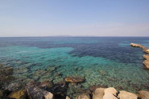 a large body of water with rocks and blue water at Antigone by Frangki in Souvala