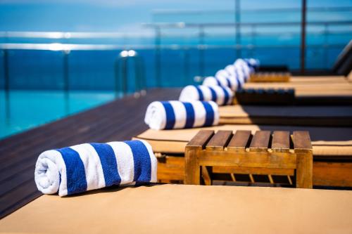 a row of benches in front of a swimming pool at Sofia Colombo City Hotel in Colombo