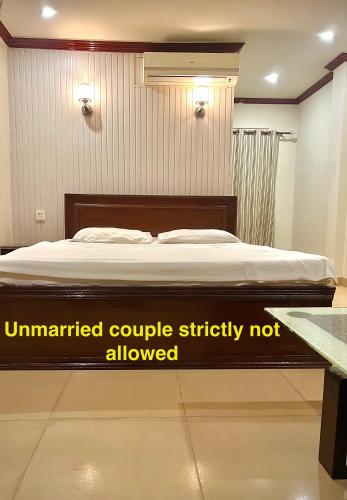 a bed in a room with amitted couple mattress not allowed at Babar House in Faisalabad