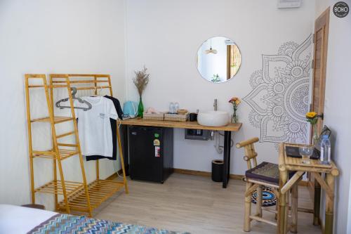 a room with a bed and a desk and a mirror at BOHO Boutique Bungalows in Baan Tai